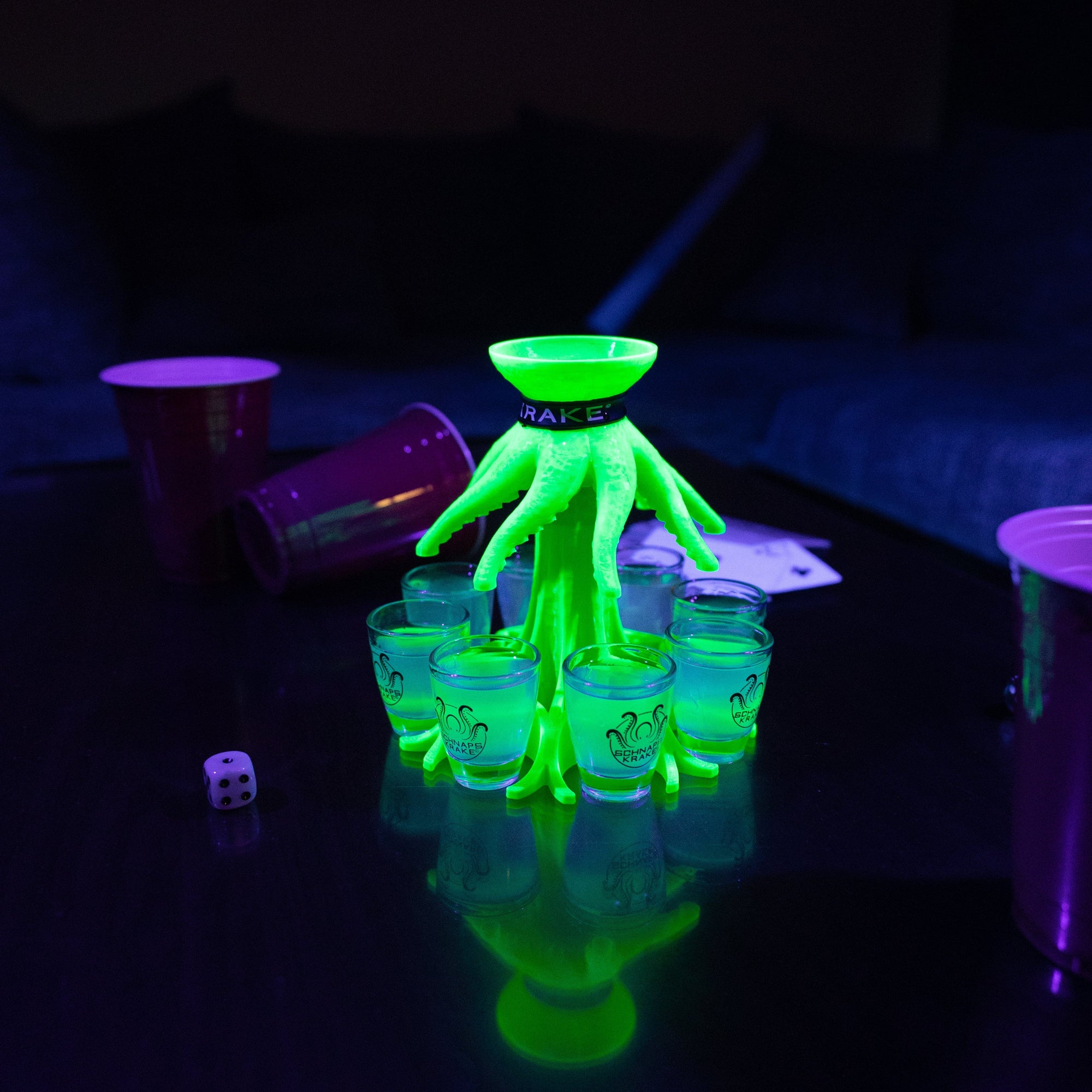 Die Schnapskrake Neon steht leuchtend auf einem Tisch